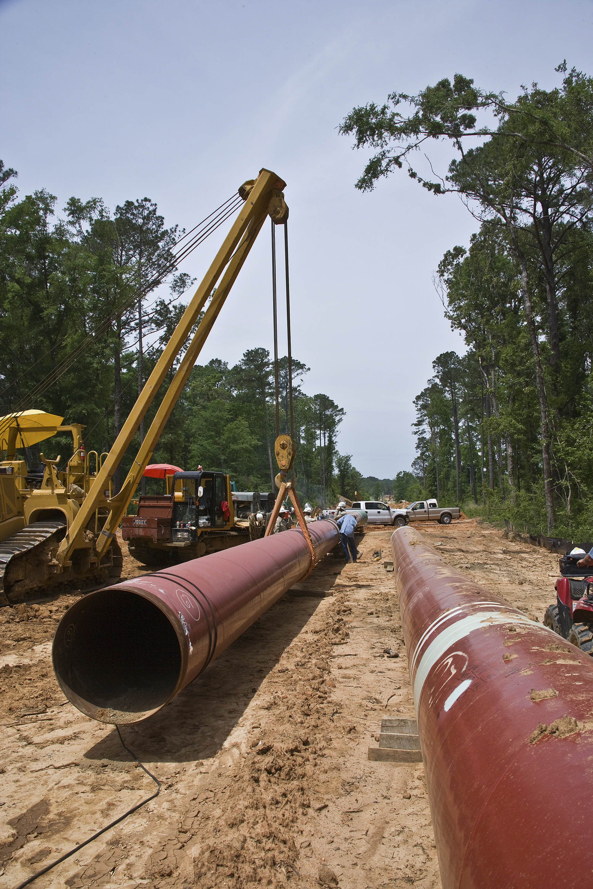 Caterpillar crane lifting pipe, Mississippi